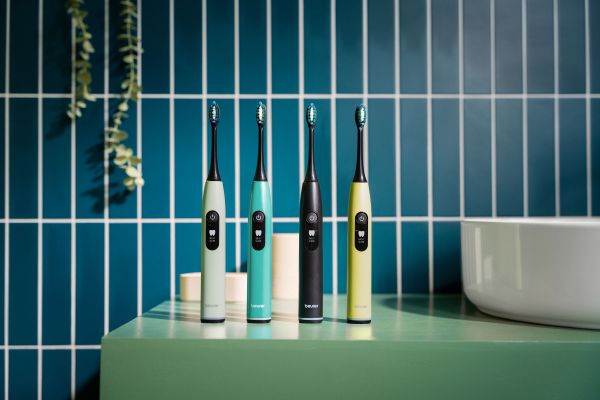 Das Bild zeigt die Schallzahnbürste SC 50 in einem Badezimmer in den Farben  Peppermint, Ocean Breeze, Midnight Ink und Splashy Lemon.