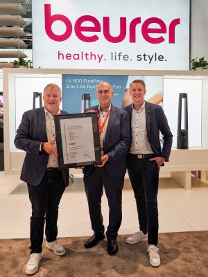 Das Bild zeigt drei Männer in Anzügen mit einer Urkunde.