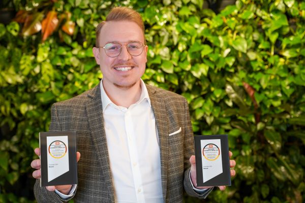 Robin Landgraf, Teamleiter Produktmanagement Medical bei Beurer, steht vor einer begrünten Wand und präsentiert den Deutschen Gesundheits-Award 2025.
