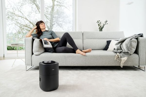 Eine Frau liegt auf einem Sofa, im Vordergrund zu sehen ist der Luftbefeuchter LB 200.