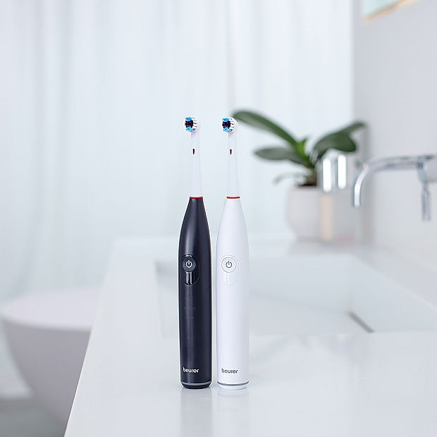 Электрические зубные щетки Beurer TB 30 и TB 50 стоят рядом на раковине.