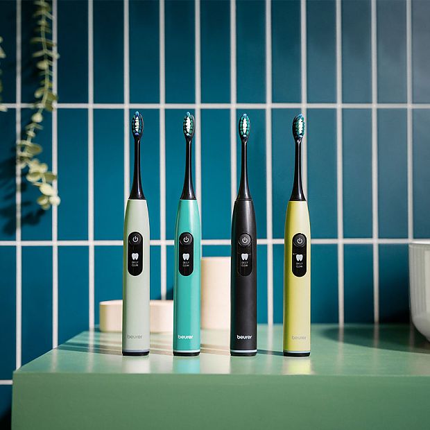Электрические зубные щетки Beurer SL 50 в 4 цветах стоят рядом на раковине.