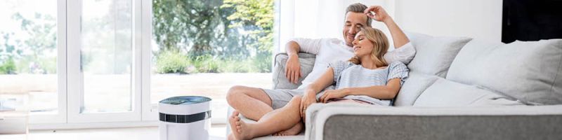 Beurer Meeresklimagerät Anwendung - Paar sitzt auf der Couch und genießt naturidentisches Meeresklima