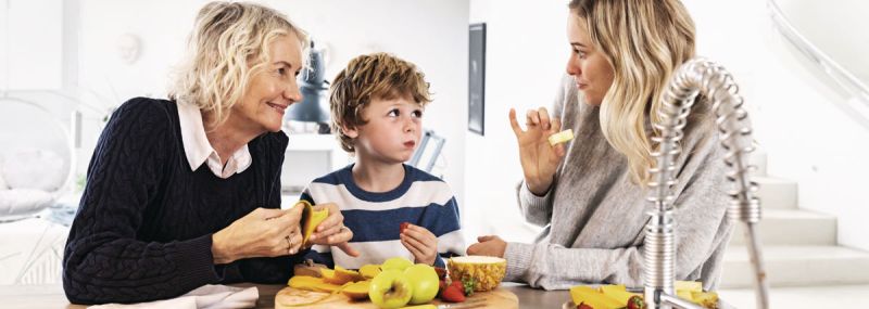 Familie isst gemeinsam Obst in der Küche