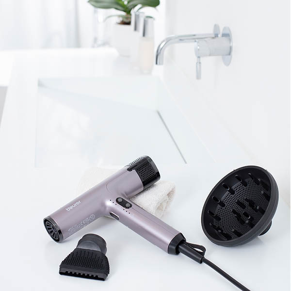 Beurer Haartrockner HC 100 liegt im Badezimmer auf dem Waschbeckenrand, daneben die zwei Aufsätze 