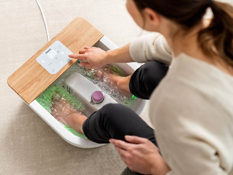 Donna gode di un benefico pediluvio con l'idromassaggiatore per il benessere plantare FB 65 di Beurer