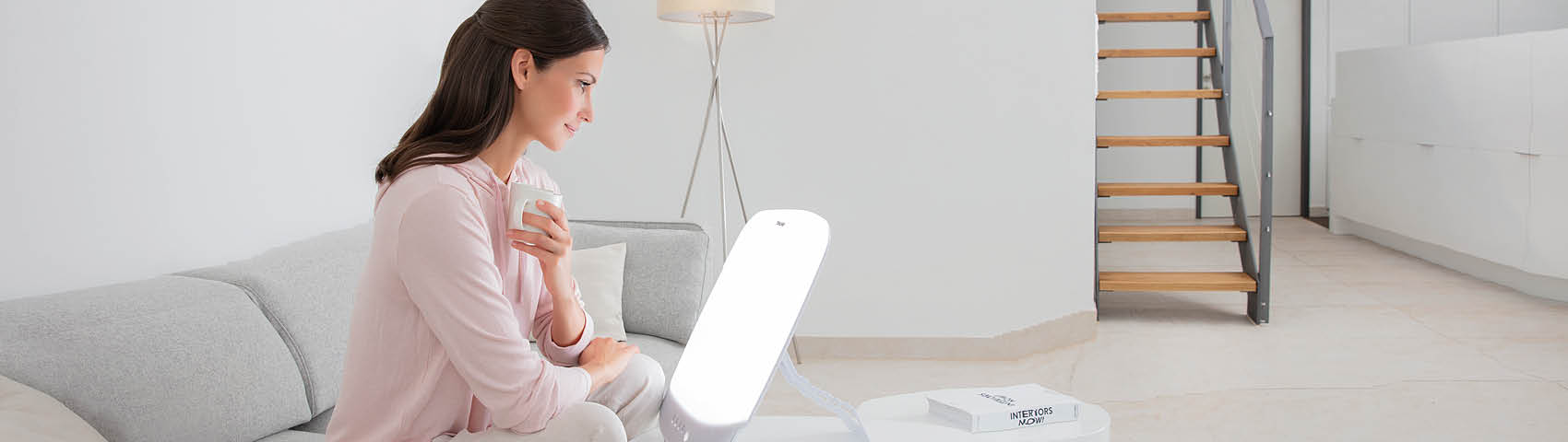 Beurer Tageslichtlampe TL 85 - Anwendungsbild Frau sitzt vor Tageslichtlampe